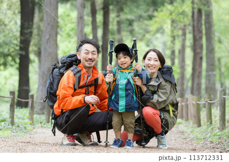 ハイキングする親子 緑の中登山やトレッキングする家族 夏のレジャーやアウトドアのお出かけのイメージ ハイキングする親子 緑の中登山やトレッキングする家族 夏のレジャーやアウトドアのお出かけのイメージ 113712331