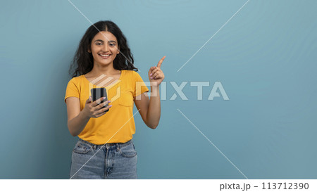 Smiling woman with phone making gesture 113712390