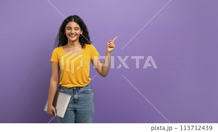 Smiling woman pointing up and holding tablet Smiling woman pointing up and holding tablet 113712439