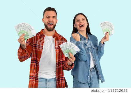 Happy couple holding cash together on blue background 113712622