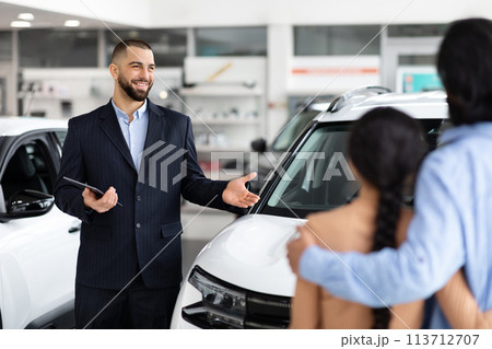 Car salesman explaining features to a hindu couple 113712707