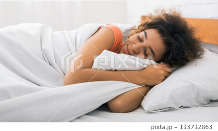 African-american woman sleeping and hugging white blanket African-american woman sleeping and hugging white blanket 113712863