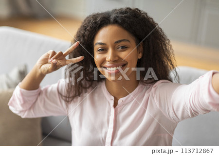 Lady taking selfie with peace sign at home Lady taking selfie with peace sign at home 113712867