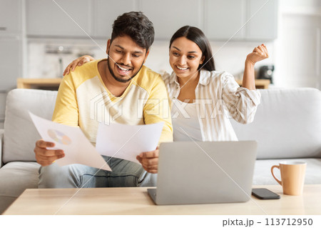 Happy couple analyzing financial documents at home Happy couple analyzing financial documents at home 113712950