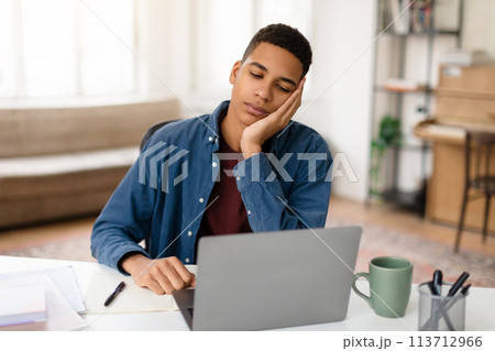 Tired man napping in front of laptop Tired man napping in front of laptop 113712966