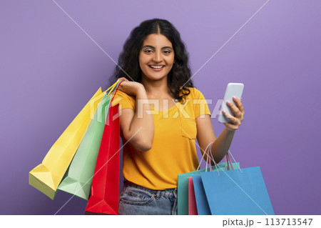 Happy shopper with colorful bags and phone 113713547