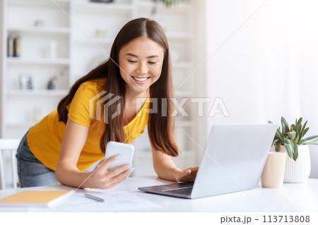 Woman texting while working on a project 113713808