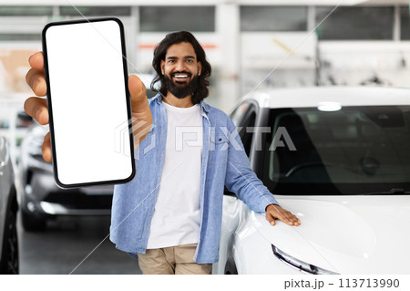Man showcasing smartphone at car dealership 113713990