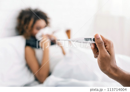 Sick woman with fever lying in bed Sick woman with fever lying in bed 113714004