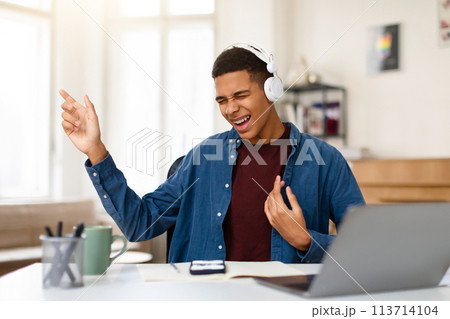 Black teen boy enjoying music, singing, imaging playing guitar 113714104