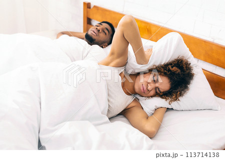 Tired and annoyed woman of her boyfriend snoring 113714138
