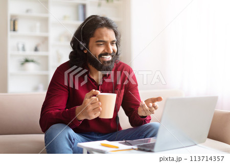 Man laughing during video call, working online Man laughing during video call, working online 113714357