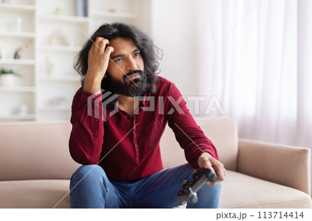 Man disappointed with video game loss at home Man disappointed with video game loss at home 113714414