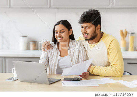 Couple engaging with finances on laptop at kicthen 113714557