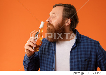 Studio portrait of bearded man smelling and tasting beer Studio portrait of bearded man smelling and tasting beer 113714558
