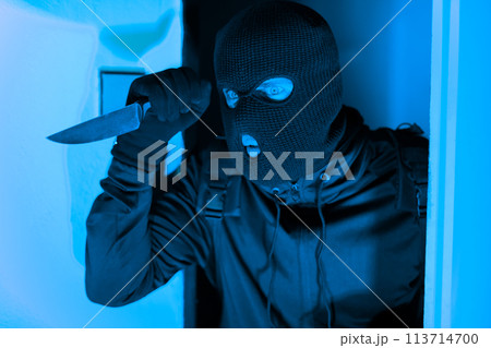 Masked thief peeking around door, break in 113714700