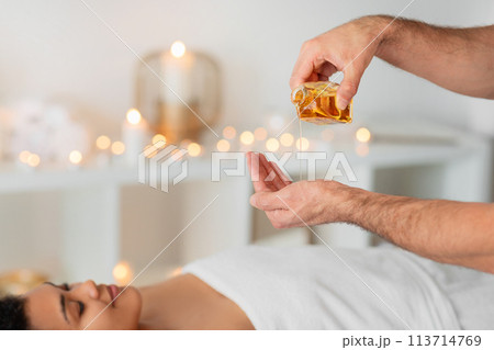 Massage oil pouring on black lady's body 113714769