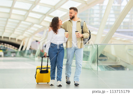 Happy couple walking in modern airport 113715179