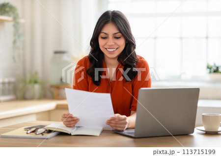 Woman reading and joyful with paper at home Woman reading and joyful with paper at home 113715199