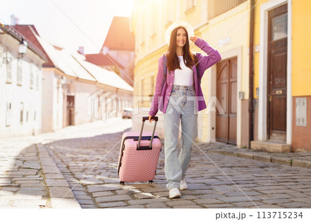 Traveler in summer hat with suitcase in European street 113715234