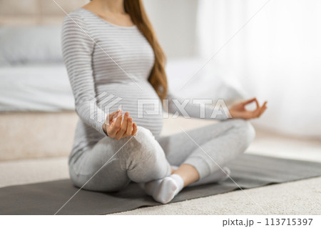 Meditating pregnant woman practicing prenatal yoga 113715397