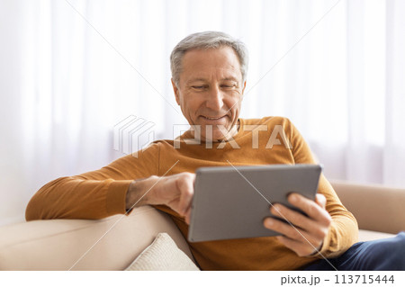 Relaxed senior man using digital tablet at home Relaxed senior man using digital tablet at home 113715444