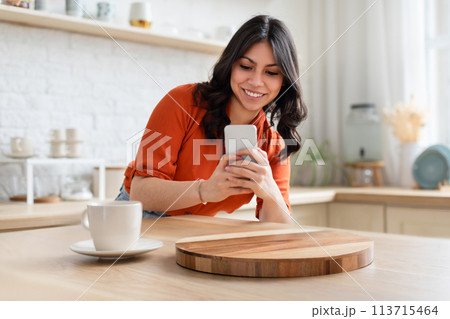 Woman using smartphone in kitchen, take a picture Woman using smartphone in kitchen, take a picture 113715464