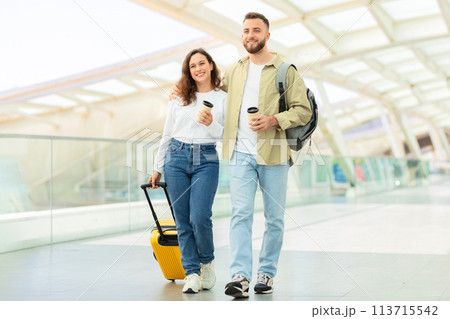 Couple strolling with a yellow suitcase 113715542