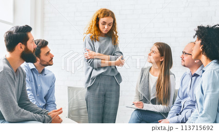Addicted woman talking talking during rehab group meeting Addicted woman talking talking during rehab group meeting 113715692