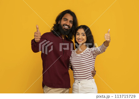 Couple gives thumbs up as woman smiles brightly Couple gives thumbs up as woman smiles brightly 113715729