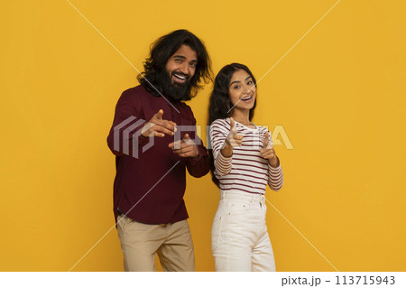 Couple pointing at viewer with excited expressions 113715943