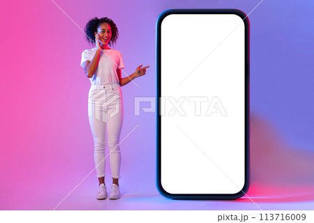Woman pointing at giant white blank phone screen 113716009