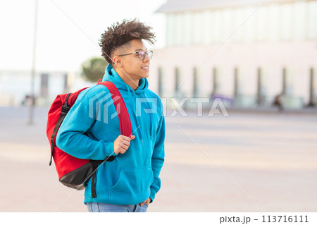 Student walking with backpack and looking away Student walking with backpack and looking away 113716111