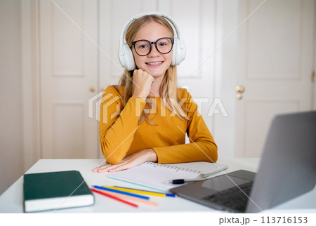 Smiling Teen Girl With Headphones Studying at Home 113716153