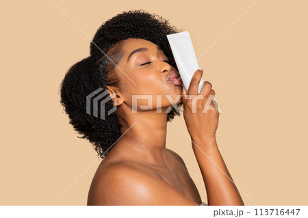 Black woman loving her skincare, kisses product tube 113716447