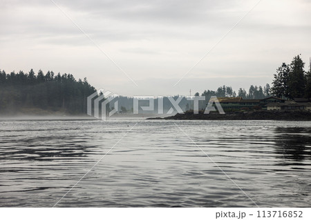 Majestic clouds hover over a vast lake framed by towering mountains Majestic clouds hover over a vast lake framed by towering mountains 113716852