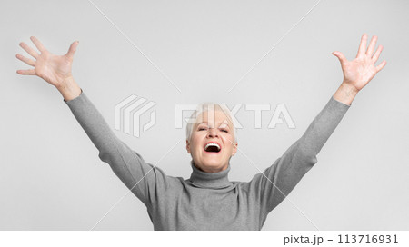 Elderly woman with arms raised and mouth open 113716931