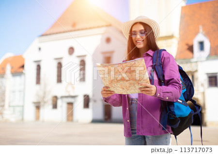 Traveling student reading a map in sun 113717073