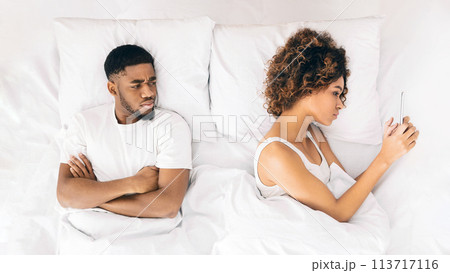 Woman reading message on phone in bed 113717116