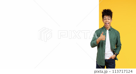 Guy giving thumbs up next to yellow backdrop Guy giving thumbs up next to yellow backdrop 113717124