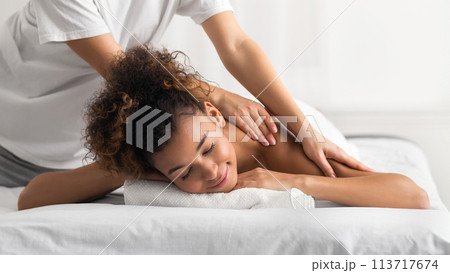 Masseur doing shoulder massage on woman body 113717674