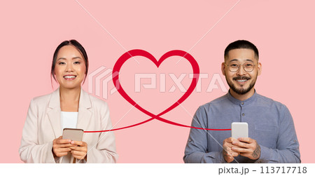 Two cheerful young adults are holding smartphones with a digitally added red heart 113717718