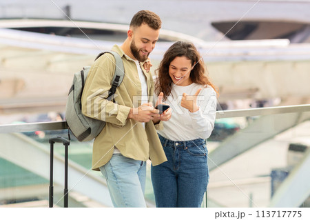 Young couple checking content on phone at airport 113717775