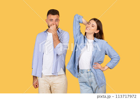 Man covering nose, woman stretching arm Man covering nose, woman stretching arm 113717972