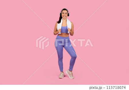 Smiling woman with headphones on pink 113718074
