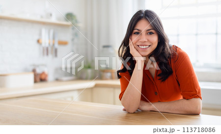 Smiling woman in modern kitchen setting, copy space 113718086