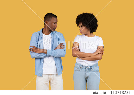 Two people with arms crossed, stern on yellow 113718281