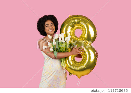 Woman with number 8 balloon and tulips smiling Woman with number 8 balloon and tulips smiling 113718686