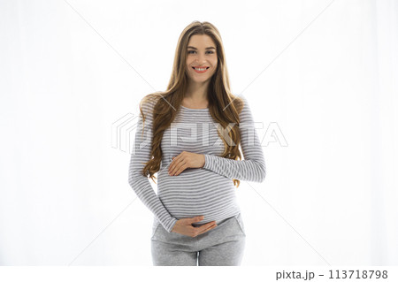 Smiling pregnant woman in casual clothes on white background Smiling pregnant woman in casual clothes on white background 113718798
