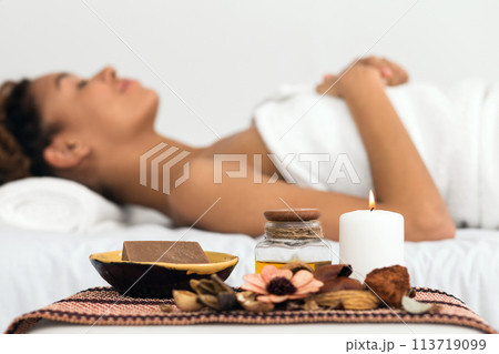 Relaxing African American lady during spa treatment 113719099